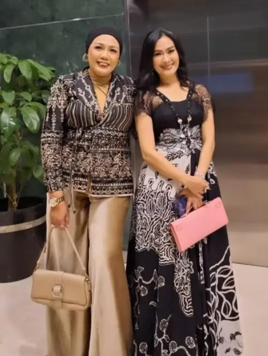 Iis Dahlia memancarkan pesona menawan maxi dress batik yang dipadukan handbag berwarna pink. [@ellysugigi_real_].