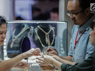 Pengunjung melihat perhiasan di salah satu stan pameran Jakarta Inernational Jewellery Fair 2019 di Jakarta, Kamis (4/4). Ajang Jakarta International Jewellery Fair 2019 diselenggarakan oleh Asosiasi Perhiasan Emas dan Permata Indonesia (APEPI) 4-7 April 2019 di JCC. (Liputan6.com/Faizal Fanani)