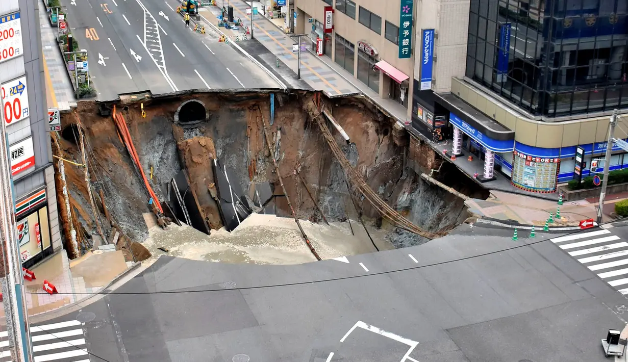 Sebuah lubang raksasa atau yang biasa disebut sinkhole tiba-tiba muncul di persimpangan dekat Stasiun Hakata, Fukuoka, Jepang, Selasa (8/11). Jalanan itu tiba-tiba runtuh hingga menciptakan lubang besar dan menghebohkan warga sekitar. (Kyodo/via REUTERS)