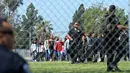 Petugas kepolisian mengevakuasi para siswa setelah insiden penembakan di SD North Park di San Bernardino, California, Senin (10/4). Polisi menyebut aksi itu sebagai pembunuhan yang diikuti bunuh diri sang pelaku (Rick Sforza/Los Angeles Daily News via AP)