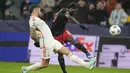 Striker RB Salzburg, Sekou Koita (kanan) melepaskan tendangan yang berusaha diblok bek Benfica, Nicolas Otamendi pada laga matchday keenam Grup D Liga Champions 2023/2024 di Red Bull Arena, Salzburg, Austria, Rabu (13/12/2023) dini hari WIB. (AP Photo/Matthias Schrader)