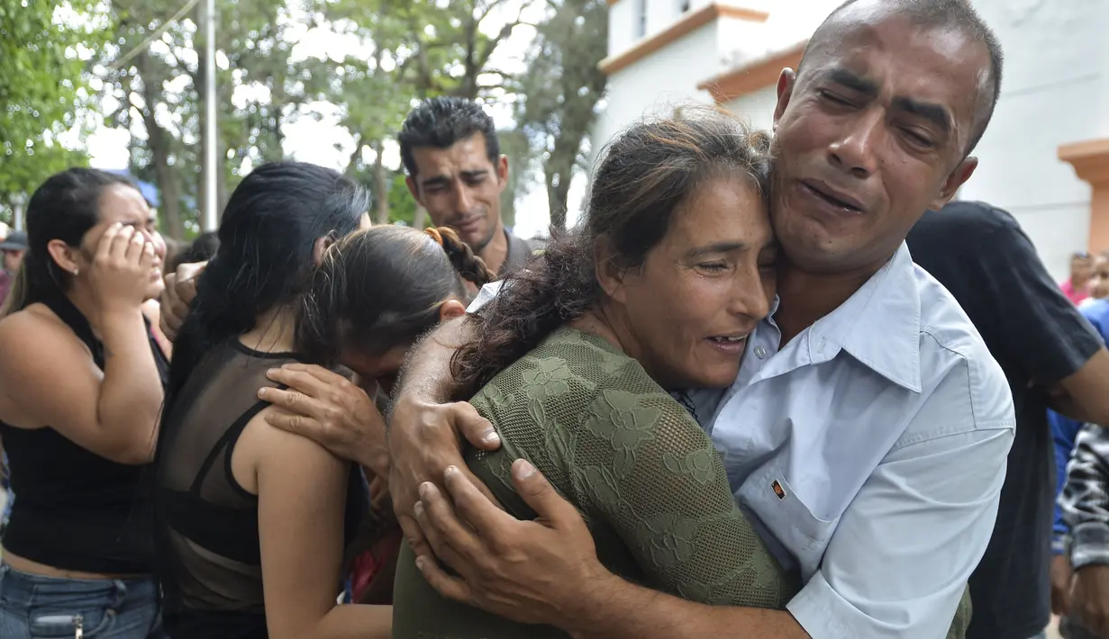 Kesedihan orang tua Jose Francisco Guerrero saat mengantar pemakamannya di San Cristobal, Tachira State, Venezuela (19/5). Awalnya Jose terjebak saat membeli makan kedalam konfrontasi antara demonstran dan petugas keamaan setempat. (AFP/Luis Robayo)