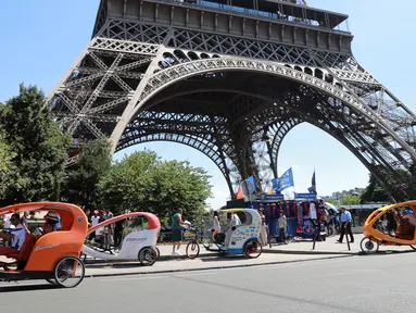 Sejumlah pengendara becak menunggu wisatawan di sekitaran Menara Eiffel, Kota Paris, Prancis, (7/7). Menurut media setempat, kemunculan becak ini membuat para sopir taksi memiliki saingan. (AFP Photo/Jacques Demarthon)