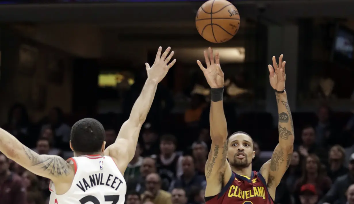 Aksi pemain  Cavaliers, George Hill (3) melakukan tembakan melewati adangan pemain Raptors, Fred VanVleet (23) pada lanjutan NBA basketball game di Quicken Loans Arena, (21/3/2018) Cleveland. Cavs menang 132-129. (AP/Tony Dejak)
