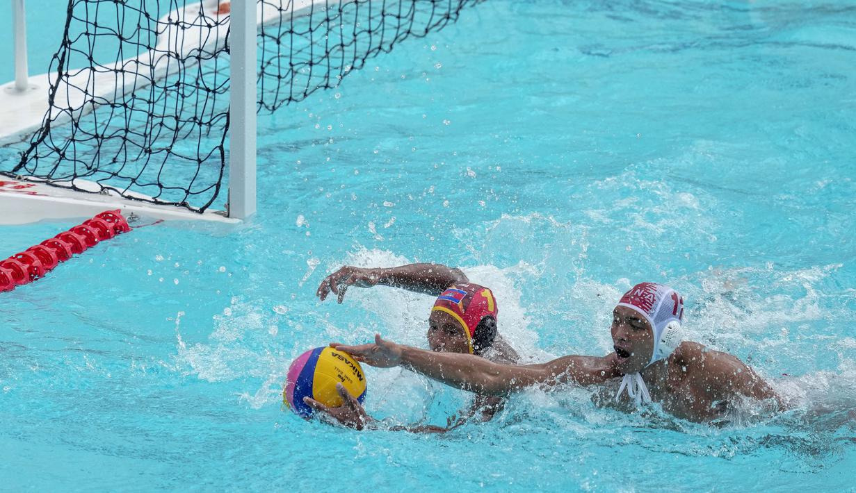 Pemain Tim Polo Air Indonesia, Rian Rinaldo (kanan) berebut bola dengan pemain Tim Polo Air Kamboja, Thoeun Chanthol pada nomor polo air putra SEA Games 2023 di Phnom Penh, Kamboja, Jumat (13/05/2023). Indonesia menang telak dengan skor 37-2. (AP Photo/Tatan Syuflana)