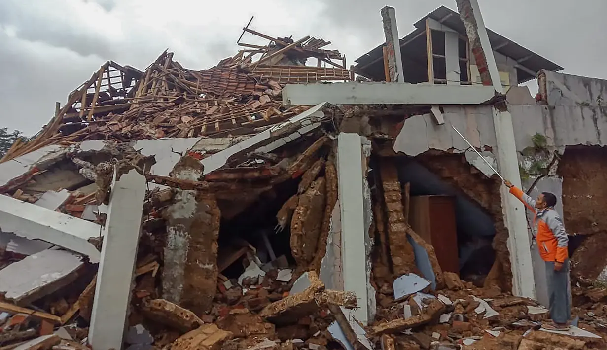 Penduduk desa memeriksa rumah mereka yang rusak setelah gempa magnitudo 5,1  di Sukabumi, Jawa Barat (10/3/2020). Hasil pemodelan menunjukkan bahwa gempabumi ini tidak berpotensi tsunami. (AFP/Handout/BNPB)