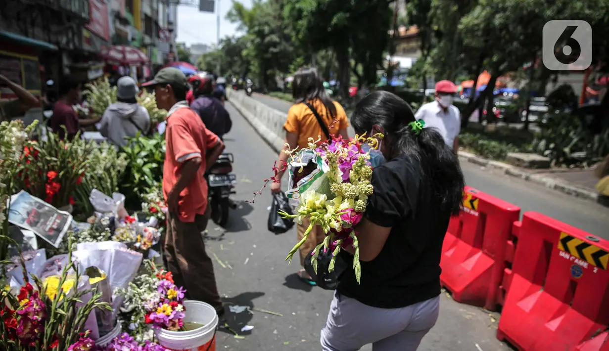 Warga membelii bunga hias di Pasar Petak Sembilan, Glodok, Jakarta, Senin (31/1/2022). Jelang tahun baru Imlek 2573 sejumlah bunga seperti sedap malam, aster, mawar dan lainnya mulai banyak dicari warga Tionghoa untuk sembahyang. (Liputan6.com/Faizal Fanani)