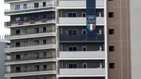 Spanduk tim dari Italia terlihat di sebuah gedung di kawasan wisma atlet Olimpiade dan Paralimpiade Tokyo 2020, di Tokyo pada Rabu (14/7/2021). Pembukaan pesta olahraga terbesar di dunia itu tinggal menghitung hari di tengah pandemi COVID-19. (Behrouz MEHRI / AFP)