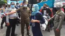 Petugas mengarahkan penumpang yang turun dari bus Antar Kota Antar Provinsi (AKAP) di Terminal bus Kalideres, Jakarta Barat, Senin (17/5/2021). Arus balik pemudik mulai terlihat di sejumlah terminal di Jakarta, salah satunya di Terminal Kalideres. (Liputan6.com/Angga Yuniar)