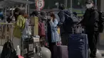 Pelancong yang mengenakan masker menunggu transportasi mereka di dekat stasiun kereta api di Beijing, Kamis (6/10/2022). Xinjiang yang luas adalah wilayah China terbaru yang terkena pembatasan perjalanan COVID-19, karena China semakin meningkatkan langkah-langkah pengendalian menjelang kongres penting Partai Komunis akhir bulan ini. (AP Photo/Andy Wong)