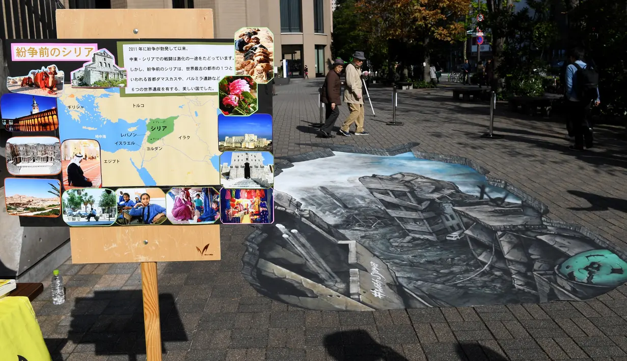 Warga berjalan di dekat karya ilusi optik 3-D yang bergambar kota Aleppo yang hancur akibat perang di kampus Universitas Meiji di Tokyo, Jepang (18/11). (AFP/Toshifumi Kitamura)