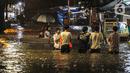 Sejumlah warga melintasi genangan banjir di kawasan Kemang, Jakarta, Selasa (4/10/2022). Jalan Kemang Utara IX tak bisa dilalui oleh kendaraan. Banjir menggenangi kawasan Pasar Kambing dan sejumlah rumah penduduk. (Liputan6.com/Faizal Fanani)