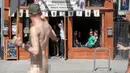 Seorang nudis menyapa warga saat mengikuti acara Nude Love Parade di San Francisco, California, AS, Minggu (17/3). Nudis adalah sebutan bagi mereka yang menjalankan tradisi telanjang. (Josh Edelson/AFP)