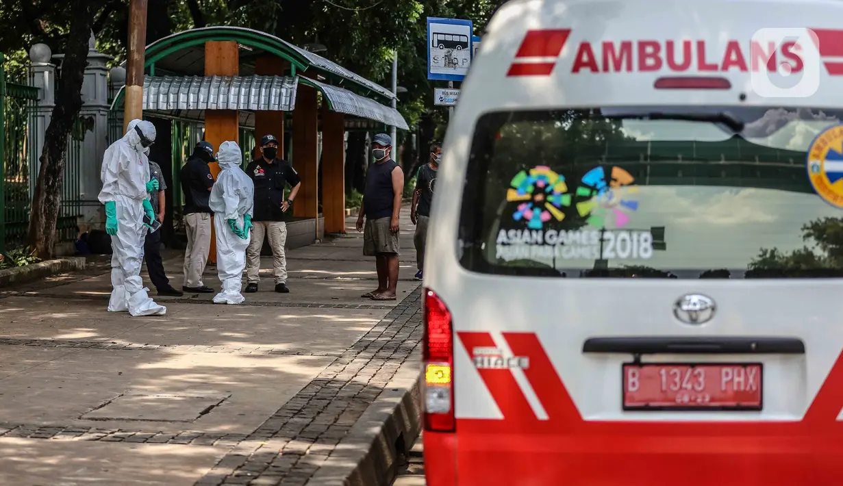 Tim medis menggunakan alat pelindung diri (APD) setelah memeriksa kondisi orang yang tergeletak di Jalan Merdeka Barat, Jakarta, Kamis (23/4/2020). Usai dilakukan pemeriksaan oleh tim medis, tunawisma tersebut dinyatakan negatif covid-19. (Liputan6.com/Faizal Fanani)