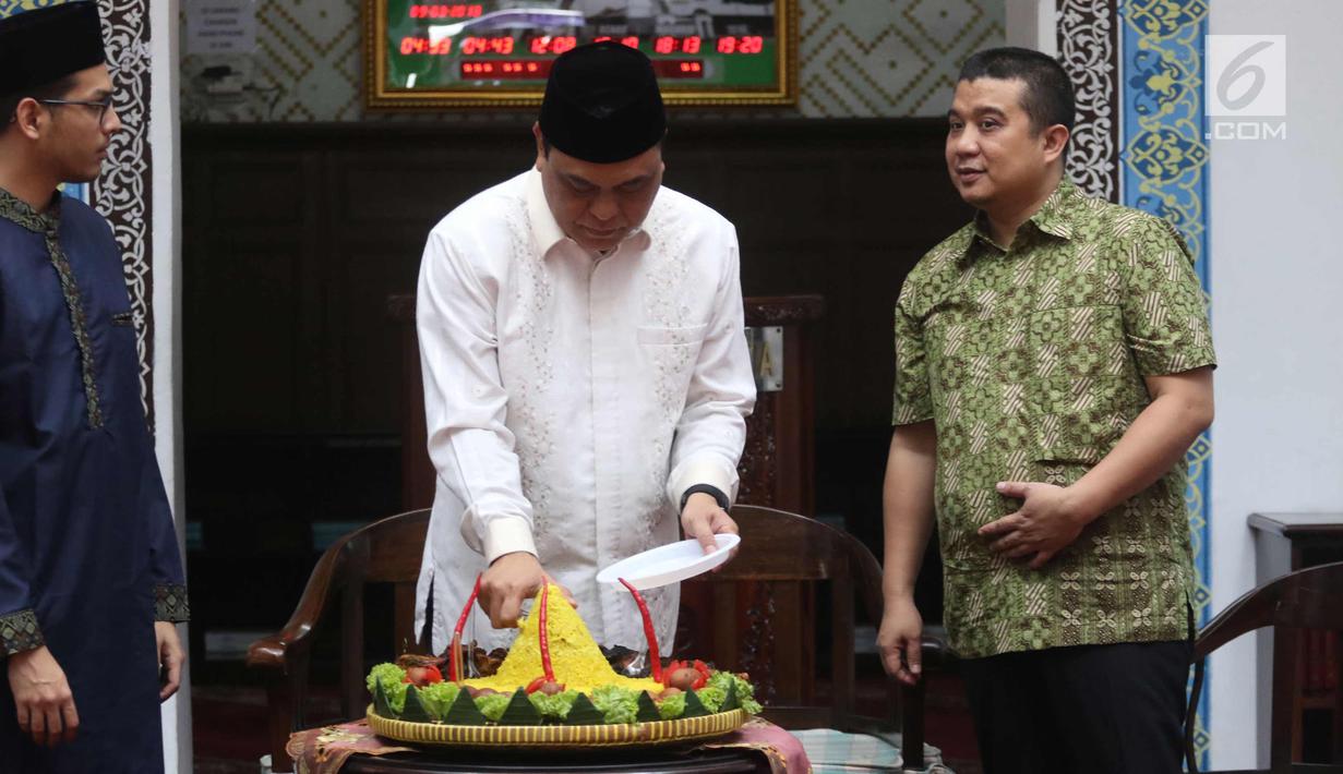 Wakil Ketua Umum DMI Komjen Pol Syafruddin didampingi Ketua Departemen Pemberdayaan Ekonomi dan Kewirausahaan DMI Erwin Aksa dan Ketum Ricma M Soekarno Hatta memotong tumpeng saat meresmikan Ricma Store, Jakarta, Jumat (9/3). (Liputan6.com/Arya Manggala)
