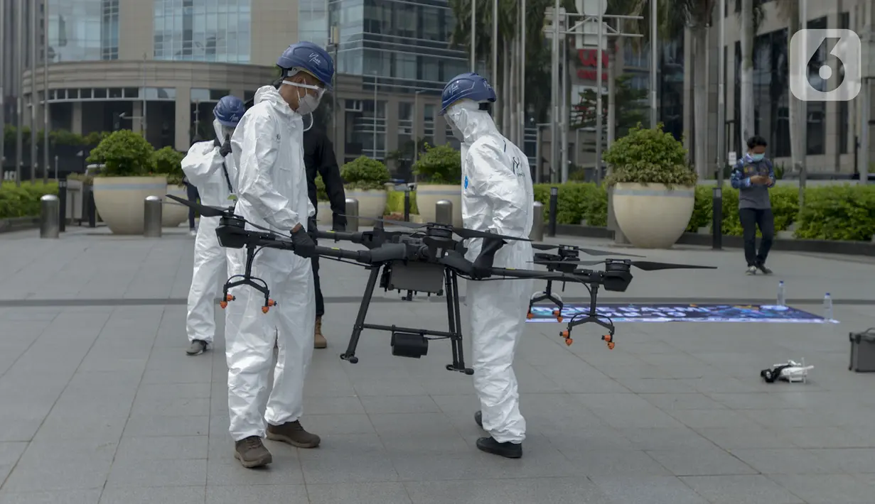 Petugas menyiapkan drone untuk menyemprotkan cairan disinfektan di Jalan Bursa Efek menuju Patung  Pemuda, Jakarta, Jumat (27/3/2020). Penyemprotan dilakukan untuk mencegah penyebaran virus corona COVID-19. (merdeka.com/Imam Buhori)