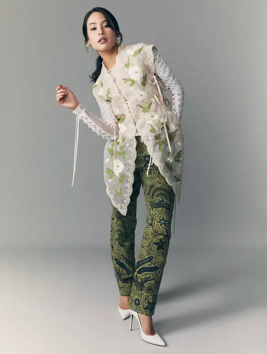 Maudy Ayunda tampil edgy dengan setelan busana dari Toton. Ia padukan long sleeve lace beraksen lilit dengan kebaya tanpa lengan dan skinny pants Batik hijau gelap [@maudyayunda]