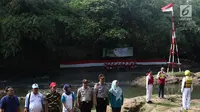 Komunitas Ciliwung bersama aparat  kepolisian mengikuti upacara bendera di Sungai Ciliwung, Jawa Barat, Jumat (17/8). Upacara di tengah aliran Sungai Ciliwung itu dalam rangka memperingati HUT ke-73 Republik Indonesia. (Liputan6.com/Immanuel Antonius)