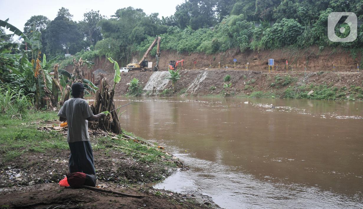 Warga memancing di dekat proyek pembangunan saringan sampah Kali Ciliwung segmen Jalan TB Simatupang, Jakarta, Minggu (12/2/2023).  Kepala Dinas Lingkungan Hidup DKI Jakarta Asep Kuswanto mengatakan pengerjaan proyek saringan sampah di Jalan TB Simatupang molor dari target. (merdeka.com/Iqbal S Nugroho)