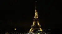 Lampu Menara Eiffel di Paris dipadamkan sebagai penghormatan kepada korban serangan teroris di Masjid Bir el-Abd, Semenanjung Sinai, Mesir (24/11). Wali Kota Paris mengatakan, menara Eifel akan menjadi gelap pada tengah malam. (AFP Photo/Thomas Samson)