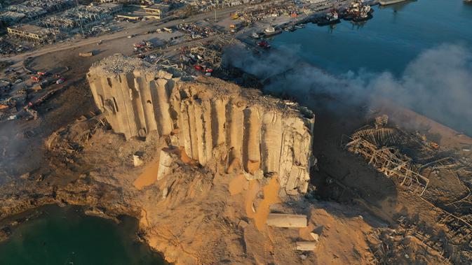 Dalam gambar drone ini, silo yang hancur berada di antara puing-puing setelah ledakan di pelabuhan Beirut, Lebanon, Rabu (5/8/2020). Ledakan di kawasan pelabuhan itu mengguncangkan seluruh ibu kota, mengguncang bangunan, dan menebarkan kepanikan di antara warganya. (AP Photo/Hussein Malla)