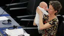 Anggota Parlemen Eropa Anneliese Dodds menggendong anaknya yang masih bayi saat mengikuti sesi voting di Strasbourg , Perancis , 14 April 2016. Wanita ini tampak santai menikmati rapat sambil mengasuh anaknya.  (REUTERS / Vincent Kessler)
