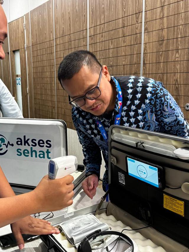 Chief Enterprise Business Officer XL Axiata, Feby Sallyanto (kanan) mencoba perangkat XL Axiata Akses Sehat di sela-sela acara peluncuran "XL Axiata Akses Sehat". Credit: XL Axiata