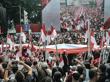 Peserta membentangkan bendera Merah Putih raksasa di kawasan Bundaran HI, Jakarta Pusat, Minggu (28/8/2022). Sebanyak 50.000 orang membentangkan bendera merah putih sepanjang 1.700 meter dari kawasan Monas hingga Bundaran HI yang merupakan rangkaian dalam memperingati Hari Kemerdekaan Indonesia dengan tema 'Pulih Lebih Cepat, Bangkit Lebih Kuat. (merdeka.com/Iqbal S Nugroho)
