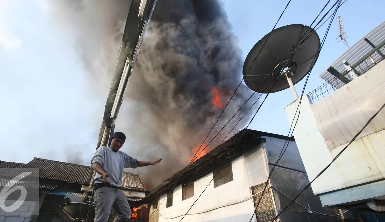 Warga berusaha memadamkan api yang membakar pemukiman penduduk di Tanah Abang, Jakarta, Senin (5/9). Sebanyak 25 unit pemadam kebakaran telah diterjunkan untuk memadamkan api yang membakar kawasan padat penduduk tersebut. (Liputan6.com/Immanuel Antonius)