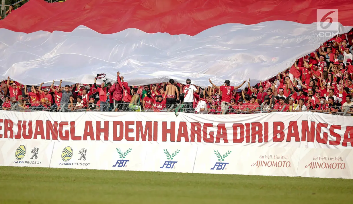 Suporter Garuda Muda membawa bendera Merah Putih raksasa saat menyaksikan laga penyisihan grup B SEA Games 2017 antara Timnas Indonesia U-22 vs Timor Leste di Stadion Selayang, Selangor, Minggu (20/8). Indonesia menang 1-0. (Liputan6.com/Faizal Fanani)