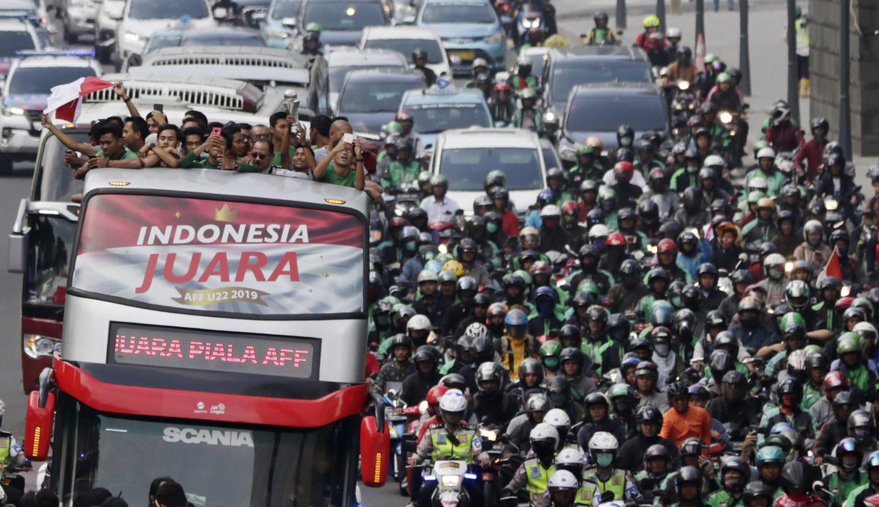 Pemain dan ofisial Timnas Indonesia U-22 menaiki bus tingkat saat konvoi menuju Istana Negara Jakarta, Kamis (28/2). Pawai tersebut untuk merayakan keberhasilan skuat Garuda Muda menjuarai Piala AFF U-22 di Kamboja. (Bola.com/M Iqbal Ichsan)