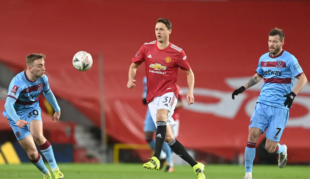 Gelandang Manchester United, Nemanja Matic (tengah) mengumpan bola dari kawalan striker West Ham United, Jarrod Bowen (kiri) dan Andriy Yarmolenko pada pertandingan perdelapan final Piala di Old Trafford, Inggris (10/2/2021). MU lolos ke perempat final Piala FA. (Michael Regan/POOL/AFP)