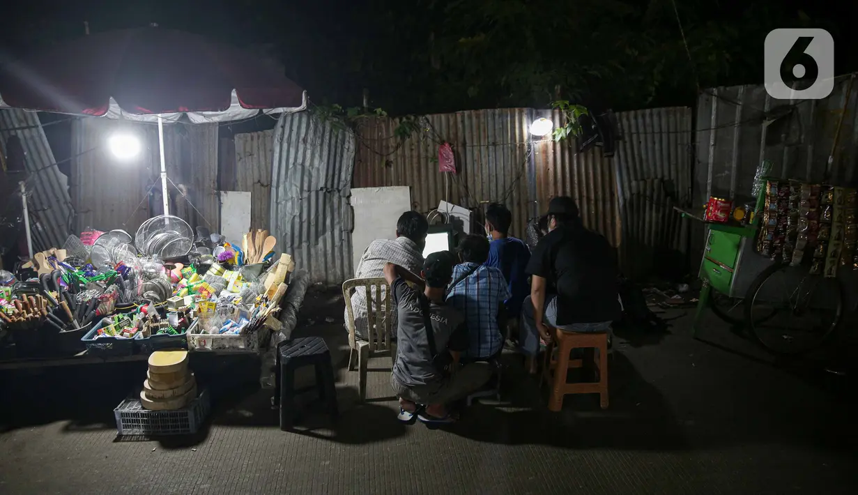 Sejumlah warga menyaksikan pertandingan laga final leg pertama Piala AFF 2020 antara Indonesia melawan Thailand melalui televisi di sejumlah tempat di kawasa Jakarta, Rabu (29/12/2021). Timnas Indonesia harus kalah dengan skor 0-4 atas Thailand. (Liputan6.com/Faizal Fanani)
