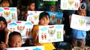 Anak-anak menunjukkan karyanya mewarnai burung garuda di Kampung Tematik Kampung Teras Pancasila, Karang Tengah, Tangerang, Banten, Rabu (1/6/2022). Kegiatan tersebut dilaksanakan dalam rangka memperingati hari lahirnya Pancasila bertujuan untuk memberikan wawasan dan pengetahuan tentang nilai-nilai Pancasila sejak dini. (Liputan6.com/Angga Yuniar)