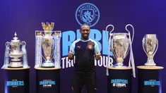 Mantan pemain Manchester City, Shaun Wright-Phillips, berfoto di depan empat trofi yang diraih The Citizen musim lalu. Trofi tersebut dipamerkan di hadapan media, di Hotel Double Three Jakarta, Indonesia, Kamis (28/9/2023). (Bola.com/Yus Mei Sawitri)