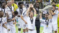 Dani Carvajal mengangkat trofi juara Piala Super Eropa 2024 didampingi rekan setimnya, Luka Modric. Los Blancos menang 2-0 atas Atalanta dan berhasil menjuarai Piala Super Eropa 2024, Kamis (15/8/2024) dini hari WIB. (AP Photo/Darko Bandic)