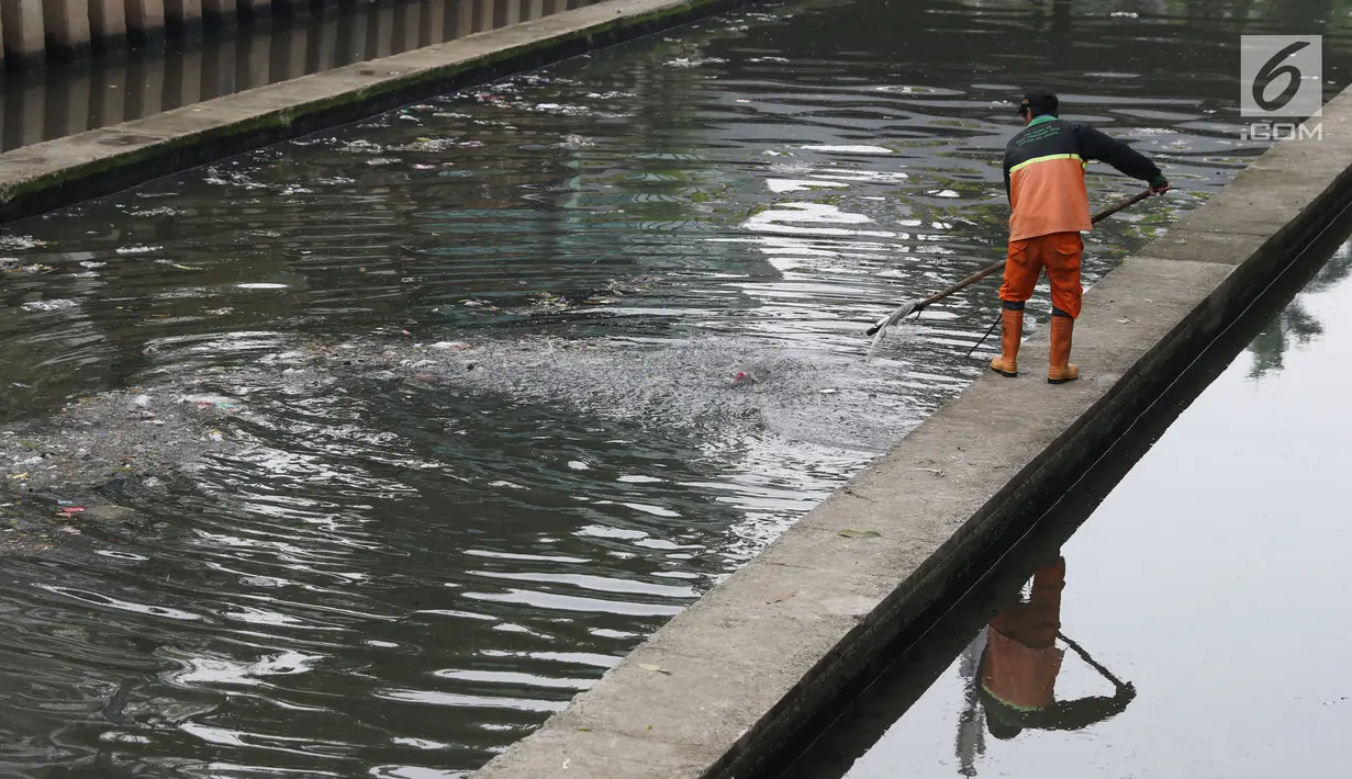 Salah satu petugas UPK Badan Air Dinas Lingkungan Hidup DKI Jakarta mengangkut ceceran sampah di Kali Cideng, Jakarta, Jumat (9/11). Pembersihan untuk mencegah terjadinya penumpukan sampah saat musim hujan di Jakarta. (Liputan6.com/Helmi Fithriansyah)
