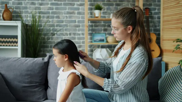 Ilustrasi seorang ibu menyisir rambut anak perempuannya setelah melakukan perawatan hair oil.