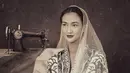 Atiqah Hasiholan tampil anggun sebagai Fatmawati. Ia mengenakan blus batik, lengkap dengan kerudung warna putih. [Foto: IG/@yudajulianofficial]