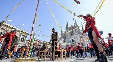 Seniman sirkus tampil di depan katedral gothic Duomo selama demonstrasi oleh pekerja sirkus di Milan, Italia utara (26/3/2021). Mereka menuntut lebih banyak dukungan dari pemerintah Italia karena kegiatan mereka ditutup sejak dimulainya wabah COVID-19. (Claudio Furlan/LaPresse via AP)