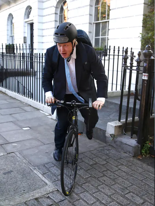 Mantan Wali Kota London, Boris Johnson menggunakan sepeda saat akan meninggalkan rumahnya di London , Inggris, (21/6). Ia merupakan anggota kelompok dari Vote Leave campaign atau kelompok yang ingin Inggris keluar dari PBB. (REUTERS / Peter Nicholls)