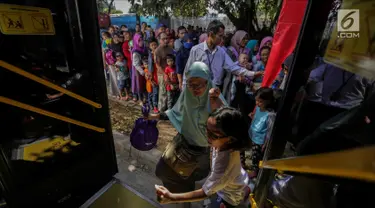 Warga menaiki bus City Tour di kawasan Masjid Istiqlal, Jakarta, Senin (25/12). Libur panjang natal membuat animo warga menggunakan bus City Tour naik drastis. (Liputan6.com/Faizal Fanani)