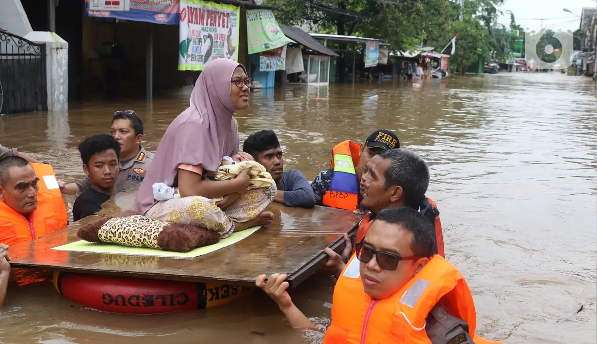 Petugas membantu mengevakuasi warga yang terjebak banjir di perumahan Ciledug Indah, Tangerang, Rabu (1/1/2020). Banjir setinggi dada orang dewasa terjadi akibat meluapnya kali angke. (Liputan6.com/Angga Yuniar)