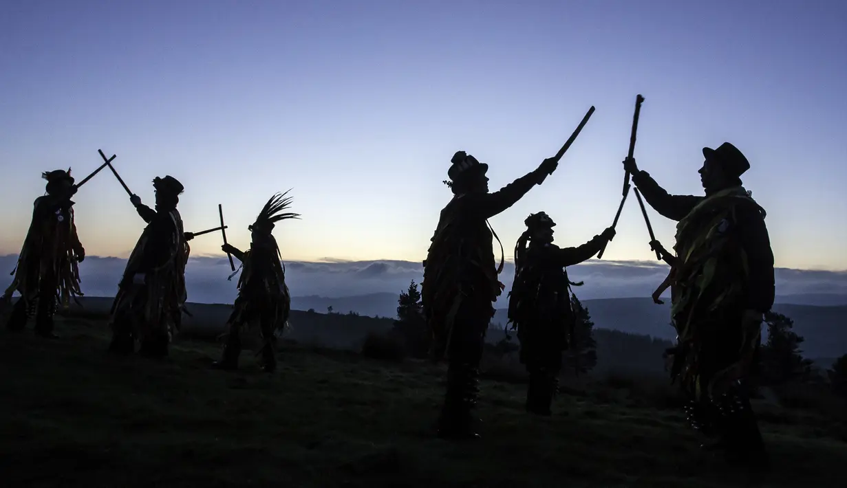 Anggota Powderkeg Morris Dancers menari di atas Windgather Rocks di High Peak di Derbyshire sebelum matahari terbit (1/5). Mereka melakukan tarian tahunan sebagai bagian dari festival Celtic kuno. (AFP Photo/Lindsey Parnaby)