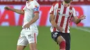 Gelandang Sevilla, Jesus Navas berebut bola udara dengan bek Athletic Bilbao,Mikel Balenziaga pada pertandingan La Liga Spanyol di stadion Ramon Sanchez Pizjuan, Seville, Selasa (4/5/2021). Kekalahan atas Bilbao, membuat Sevilla gagal mendekati tiga tim teratas Liga Spanyol. (AFP/Cristina Quicler)