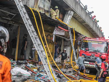 Pedagang menyelamatkan barang dagangan saat proses pendinginan oleh damkar dari kebakaran di Pasar Pagi Asemka, Jakarta, Jumat (18/11/2022). Kebakaran terjadi sekitar pukul 11.30 WIB. Sebanyak Sebanyak 14 unit kendaraan pemadam beserta 70 personel dikerahkan untuk menanggulangi kebakaran. (Liputan6.com/Faizal Fanani)