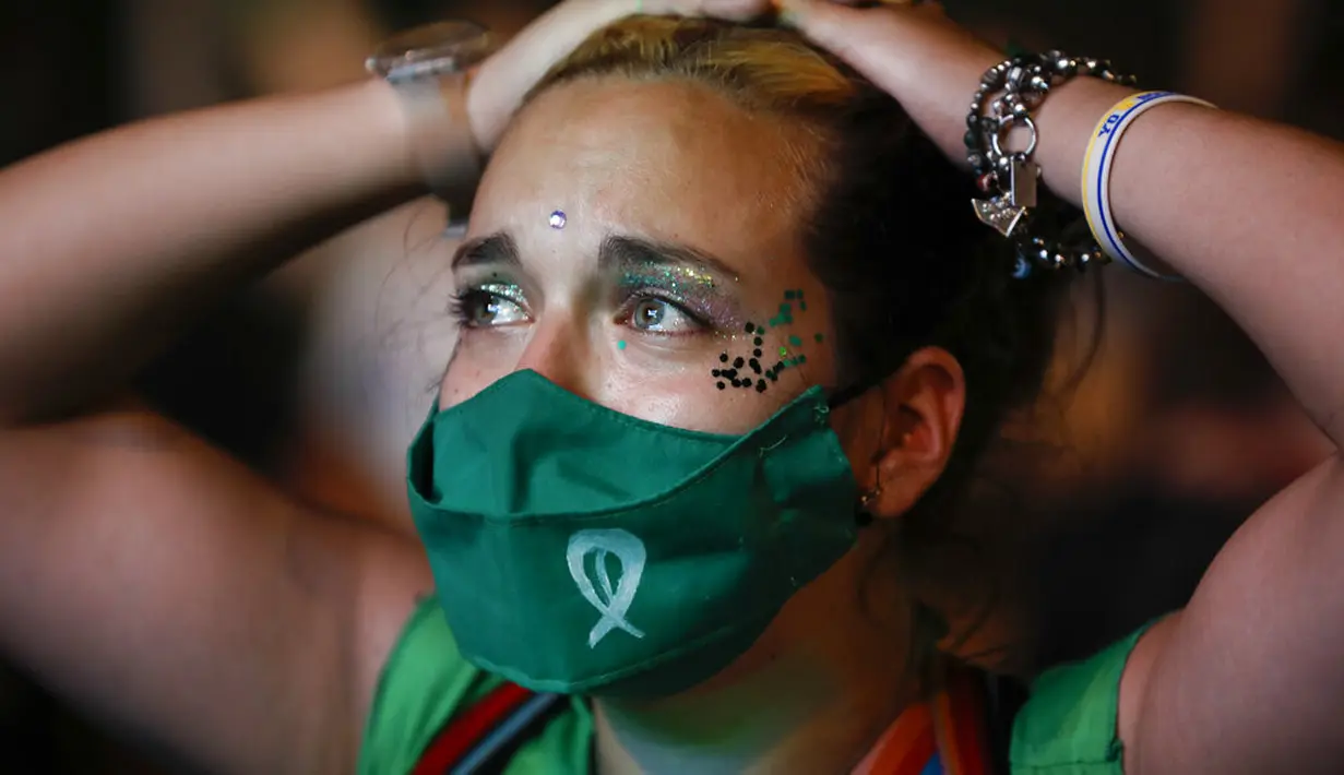 Ekspresi aktivis hak-hak aborsi saat menonton siaran langsung sidang parlemen di luar Kongres, Buenos Aires, Argentina, Rabu (30/12/2020). Argentina memastikan sebagai negara Amerika Latin pertama yang melegalkan aborsi. (AP Photo/Natacha Pisarenko)