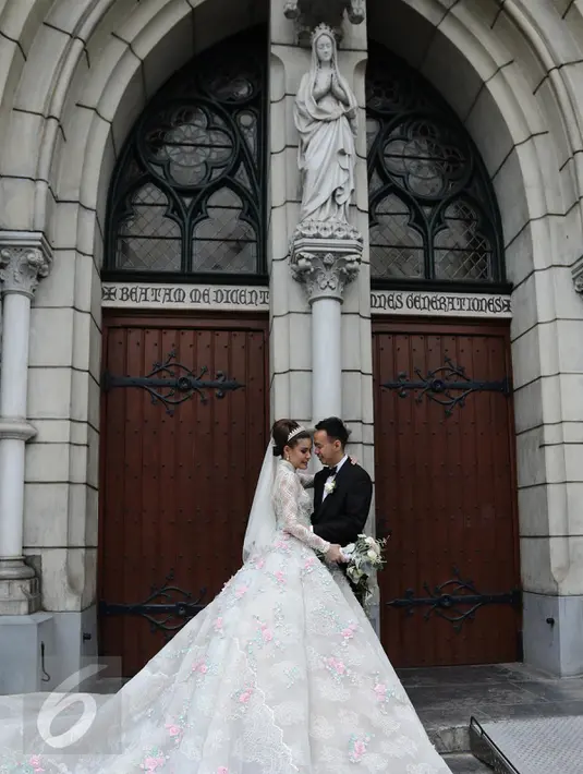 Pasangan Selebritis Olga Lydia dan Aris berpose seusai menjalankan sakramen pernikahan di Gereja Katedral, Jakarta, Jumat (21/4). Aktris Olga Lydia dan Aris Utama menjalankan sakramen pernikahan. (Liputan6.com/Herman Zakharia)