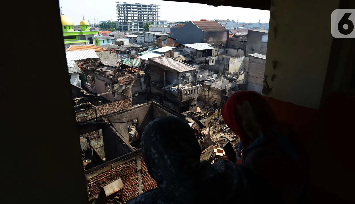 Warga melihat sisa kebakaran di RW 02, Kelurahan Bidari Cina, Jakarta, Selasa (22/10/2019). Sebanyak 56 rumah di pemukiman padat penduduk tersebut hangus terbakar pada Senin, 21 Oktober 2019. (merdeka.com/Imam Buhori)
