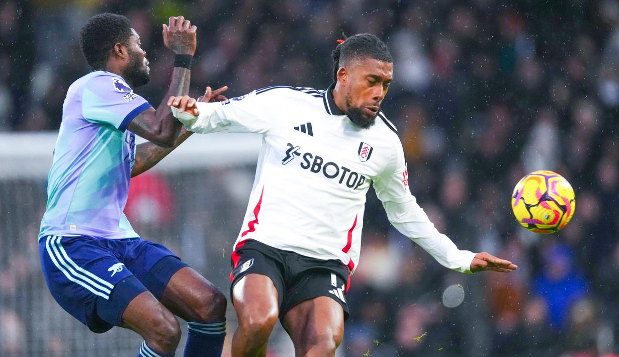 Arsenal harus puas meraih satu poin kala bertandang ke markas Fulham. Kedua tim bermain imbang 1-1.  (AP Photo/Dave Shopland)